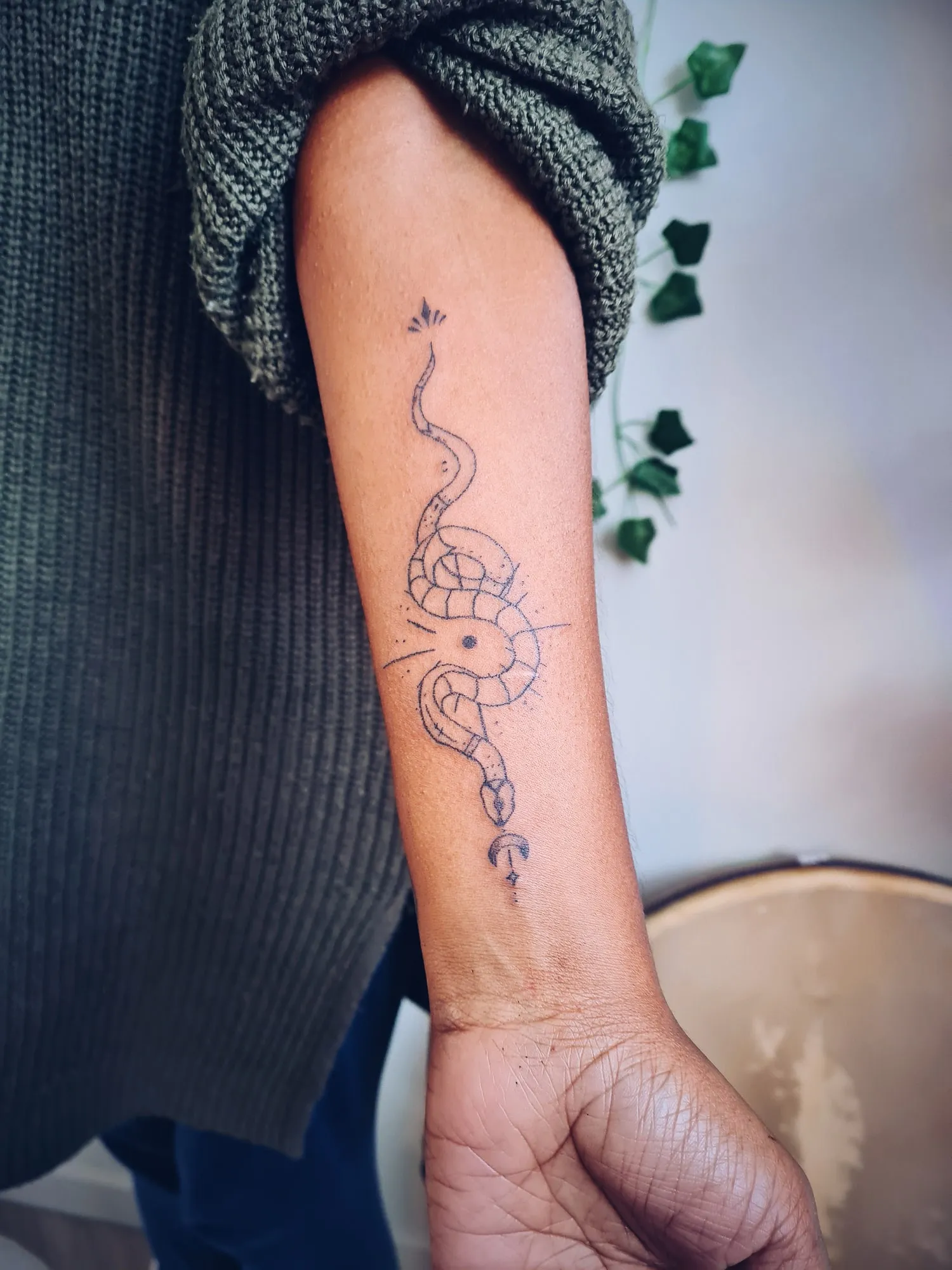 Tattoo van een slang op de onderarm, van opzij