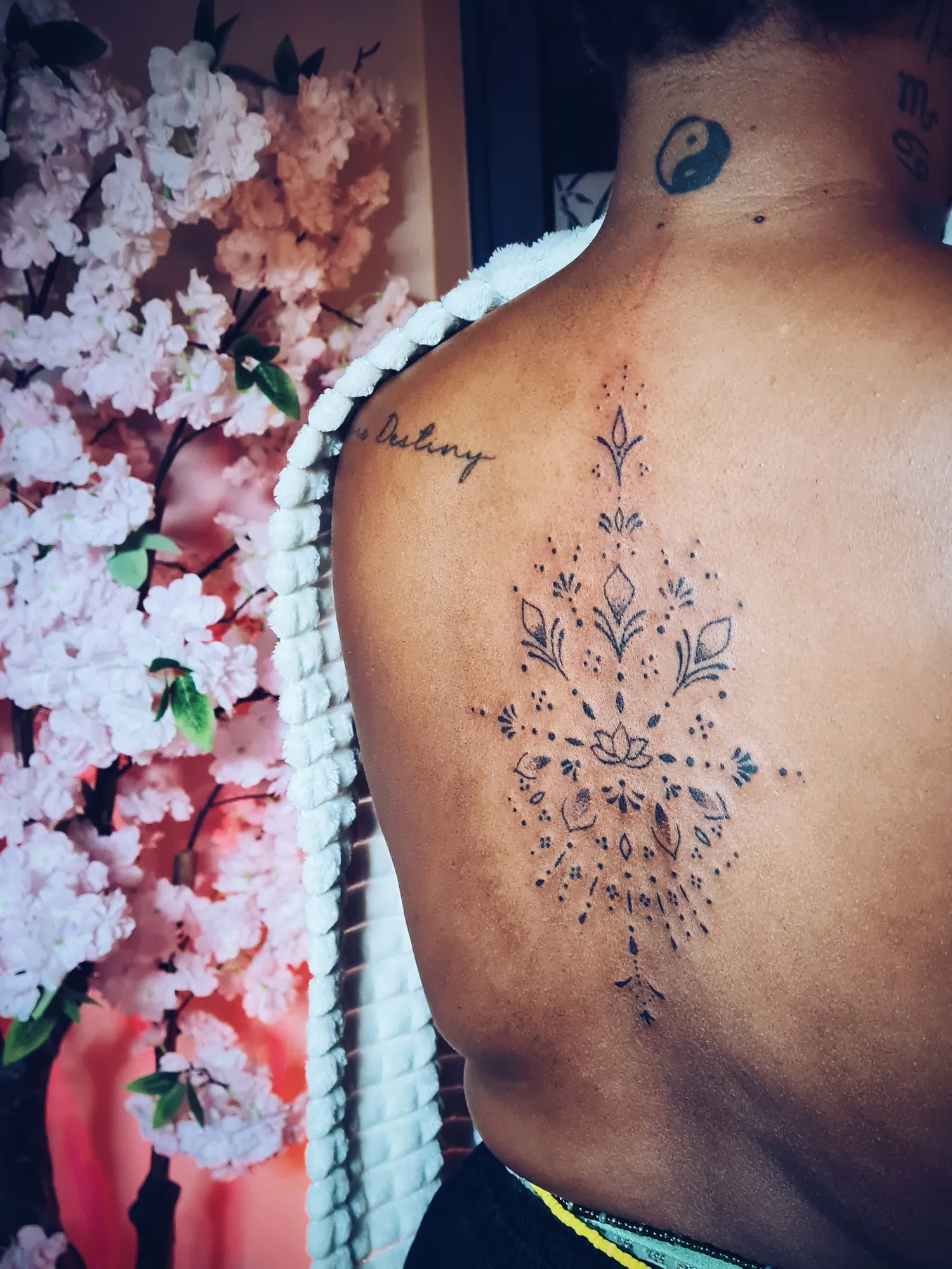 Ornamentele mandala-tattoo tussen de schouderbladen