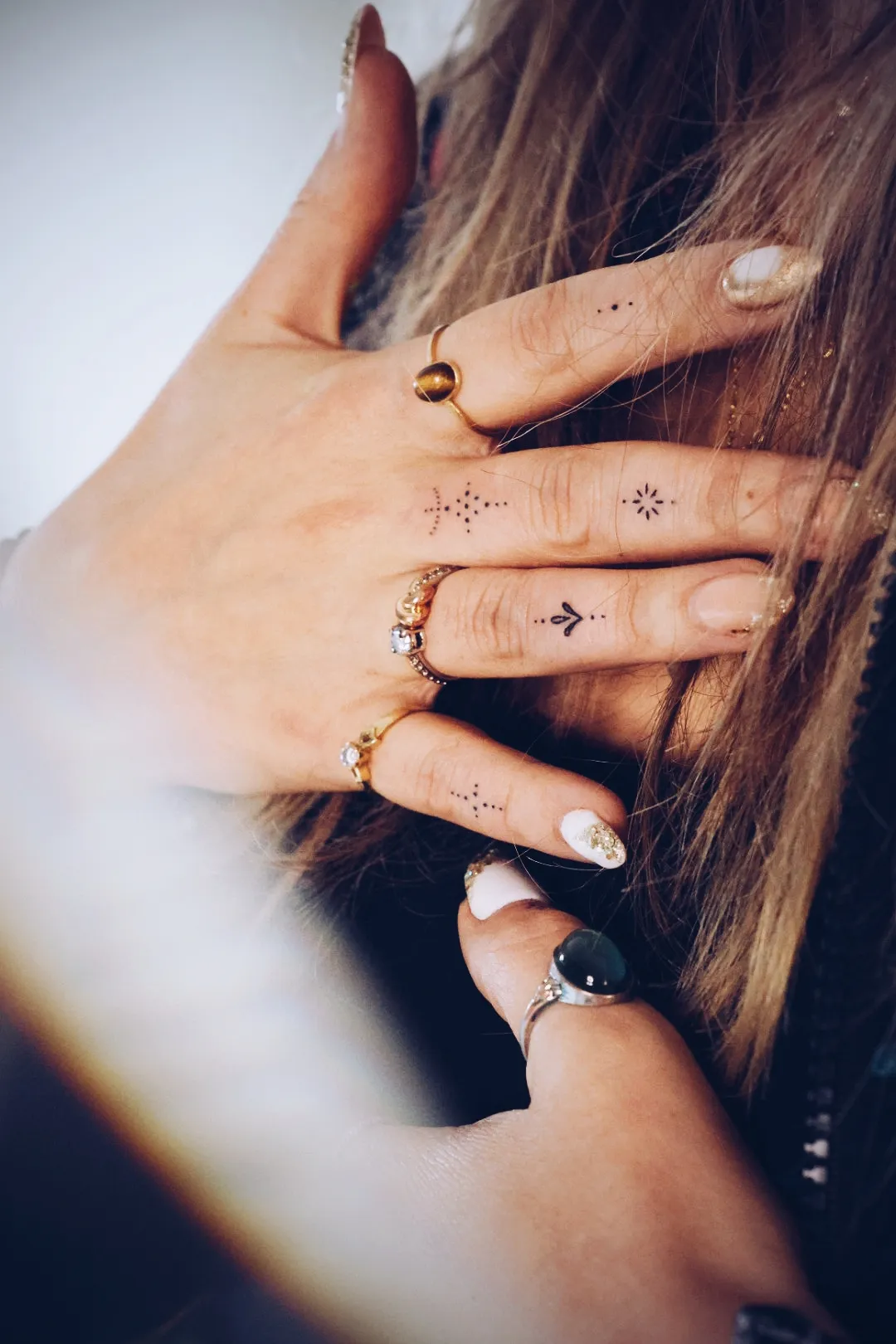 Hand met fijne tattoos op de vingers