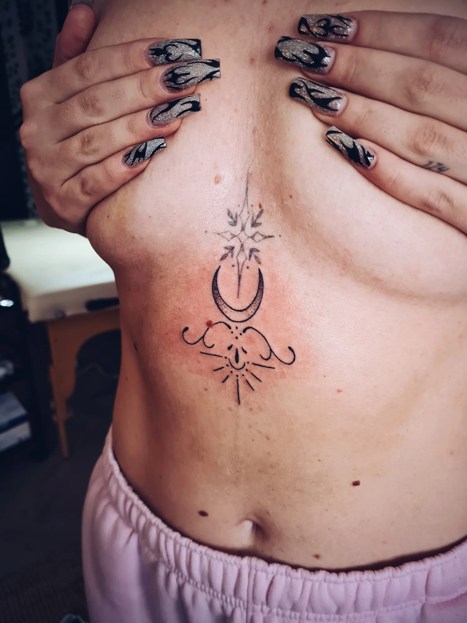 Tattoo van een maansikkel op het borstbeen