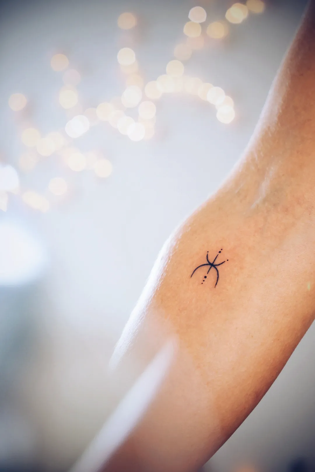 Kleine symbooltattoo op een arm